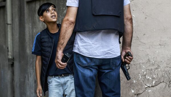 Турецкий полицейский задает вопросы курдскому мальчику после нападения на полицейских в городе Диярбакыр