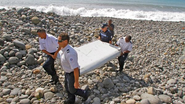 Полицейские несут обломки самолета, найденные в Сен-Андре, Реюньон