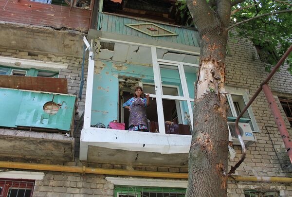 Женщина на балконе квартиры в Горловке после обстрела