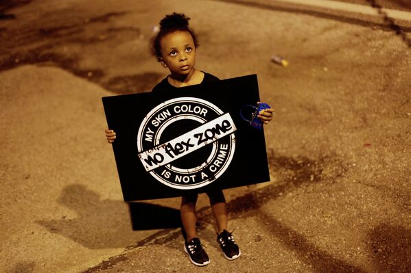 Девочка с плакатом во время протестов в городе Фергюсон, США