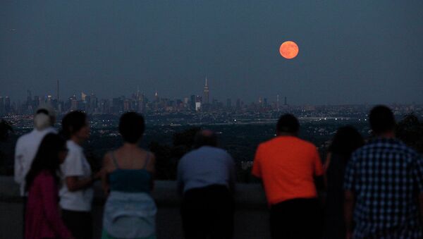 Люди наблюдают за голубой луной в небе над Нью-Йорком