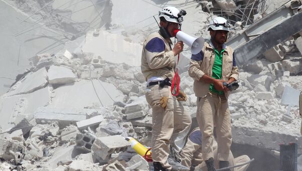 Спасатели на месте падения истребителя сирийской армии в жилом районе города Эриха