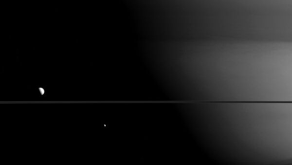 Совместное изображение двух естественных спутников Сатурна – Мимаса и Дионы, созданное космическим кораблем Кассини