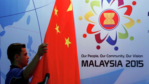 Рабочий устанавливает китайский национальный флаг готовясь к пресс-конференции Ассоциации государств Юго-Восточной Азии