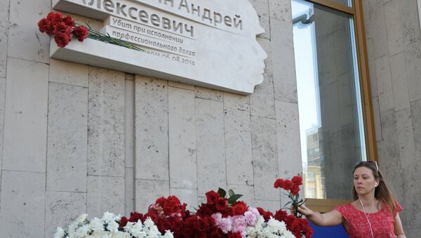 Коллега возлагает цветы к мемориальной доске в честь фотокорреспондента МИА Россия сегодня Андрея Стенина