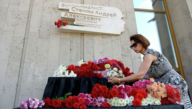 Коллега возлагает цветы к мемориальной доске в честь фотокорреспондента МИА Россия сегодня Андрея Стенина