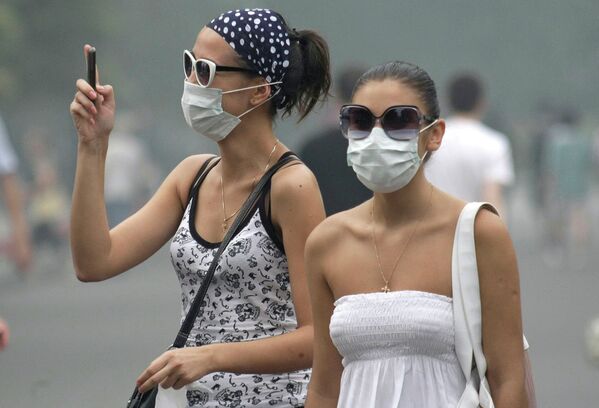 Девушки в защитных масках на одной из улиц Москвы во время смога