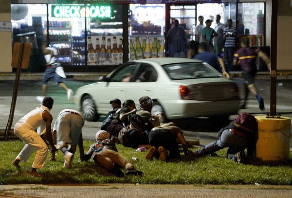 Люди укрываются от стрельбы во время протестов в Фергюсоне
