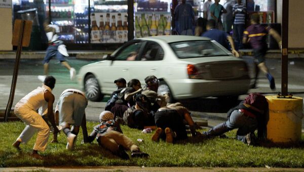 Люди укрываются от стрельбы во время протестов в Фергюсоне