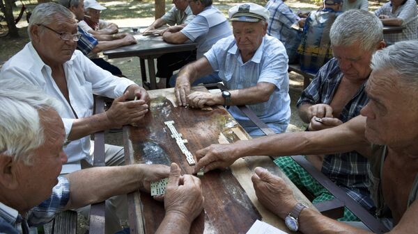 Пенсионеры играют в домино в парке города Евпатория