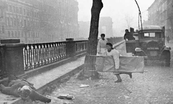 Медсестра подбегает к раненому в блокадном Ленинграде