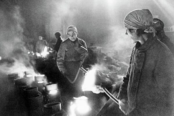 Женщины на заводе льют металл во время блокады Ленинграда