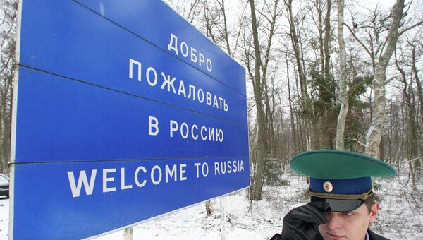 Пограничник у информационного щита Добро пожаловать в Россию. Архивное фото