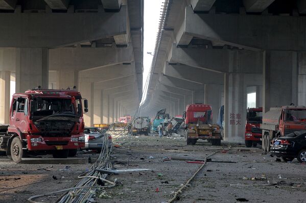 Поврежденные автомобили в результате взрывов на складе опасных веществ в промышленном городе Тяньцзинь в Китае