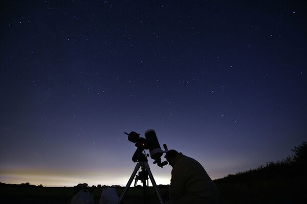Астроном во время наблюдения метеоритного дождя Персеиды на севере Англии
