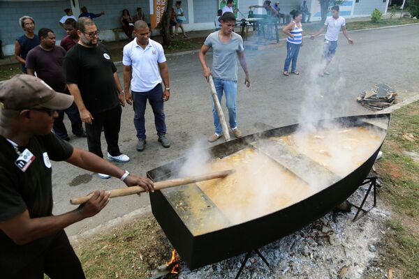 Местные жители готовят еду, отмечая день рождения Фиделя Кастро