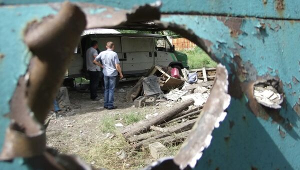Дыра в воротах одного из домов от попадания осколка от снаряда в результате обстрела Донецка