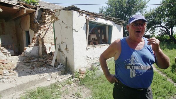 Житель деревни Новомарьевка на фоне разрушенного дома. Архивное фото