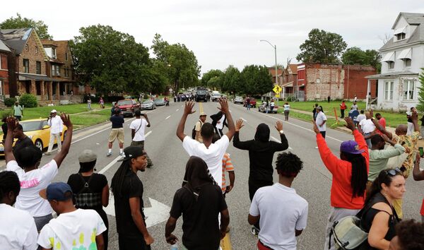 Местные жители и полицейские на улице Сент-Луиса после инцидента, в ходе которого был застрелен афроамериканец