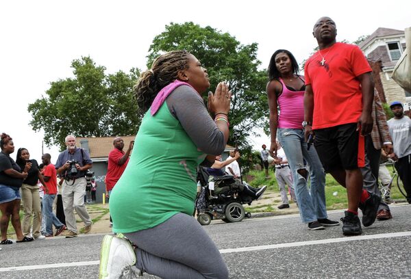 Местные жители на улице Сент-Луиса после инцидента, в ходе которого был застрелен афроамериканец