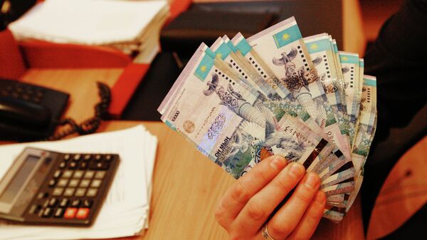 Тенге - национальная валюта Казахстана в одном из обменных пунктов в Алма-Ате