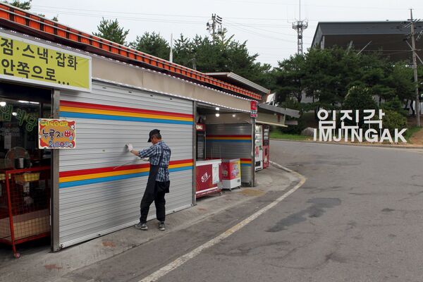 Мужчина закрывает магазин, расположенный в районе демилитаризованной зоны, разделяющей Северную и Южную Корею