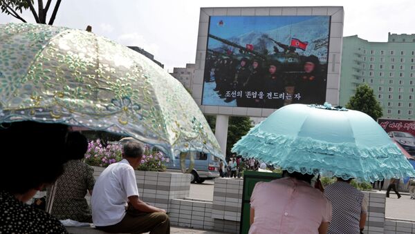 Жители Пхеньяна смотрят пропагандистский фильм на улице города