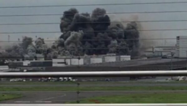 Густой дым поднялся над заводом в Токио во время пожара. Съемка очевидца