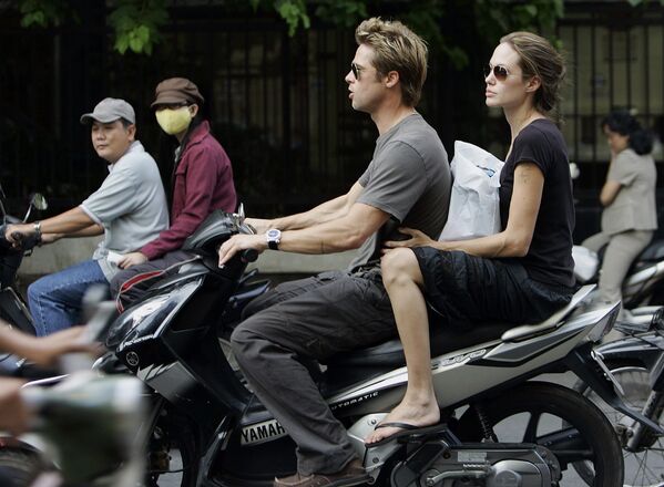 Брэд Питт и Анджелина Джоли едут на скутере по улице Хошимина, Вьетнам