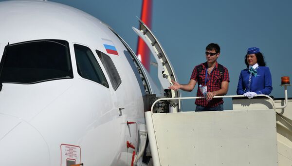 Посетители выставки осматривают самолет Sukhoi Superjet 100