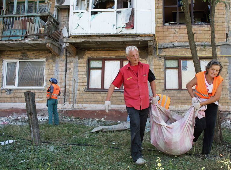 Жители Горловки убирают территорию около многоквартирного жилого дома на улице Кирова