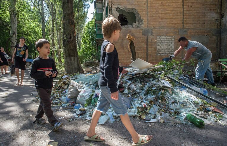 Жители Горловки убирают территорию около многоквартирного жилого дома на улице Кирова