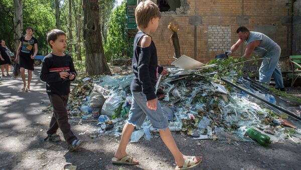 Жители Горловки убирают территорию около многоквартирного жилого дома на улице Кирова