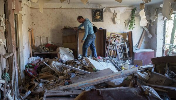 Жители Горловки в разрушенной квартире. Архивное фото