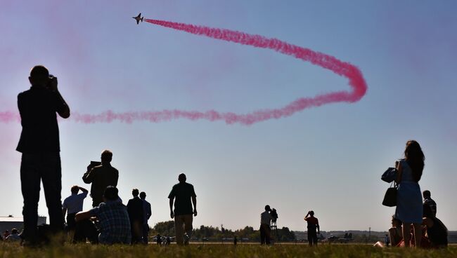 Посетители салона наблюдают за выступлением самолета Як-130 во время открытия Международного авиационно-космического салона МАКС-2015