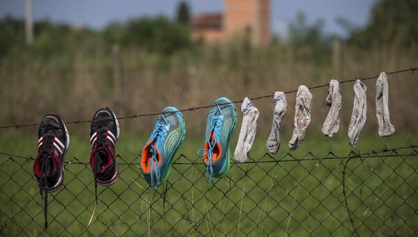 Обувь и носки сирийских беженцев сушатся на заборе неподалеку от границы Сербии с Венгрией