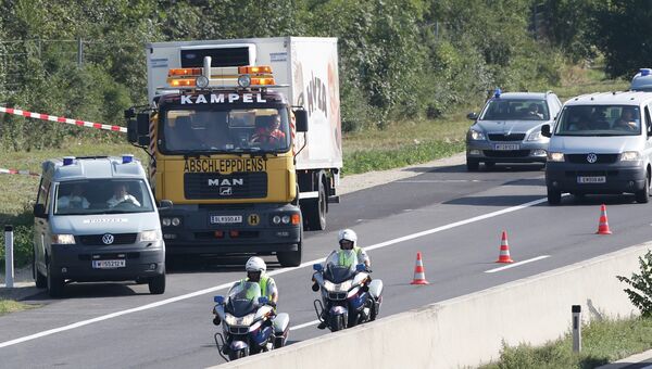 Сотрудники австрийской полиции сопровождают фургон, в котором перевозились мигранты. 27 августа 2015