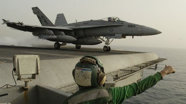 Американский штурмовик F/A-18 Hornet взлетает с палубы авианосца Китти Хоук в Персидском заливе. Архивное фото