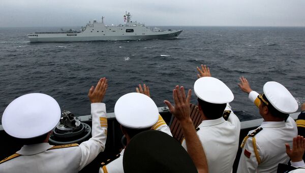 Адмиралы и офицеры объединенного руководства учениями приветствуют моряков десантного корабля ВМС НОАК КНР Чанбайшань во время военно-морского парада в заливе Петра Великого
