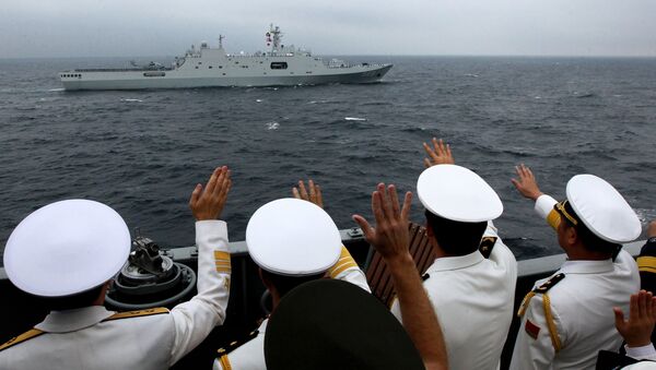 Адмиралы и офицеры объединенного руководства учениями приветствуют моряков десантного корабля ВМС НОАК КНР Чанбайшань во время военно-морского парада в заливе Петра Великого