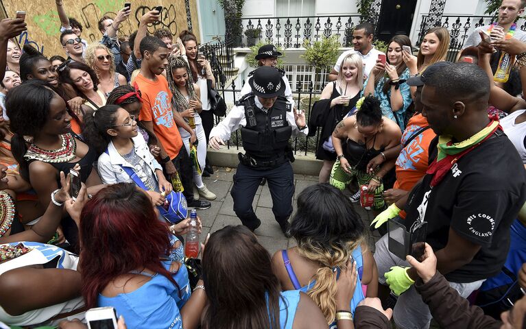 Полицейские танцуют во время парада Notting Hill Carnival в западном Лондоне. Август 2015