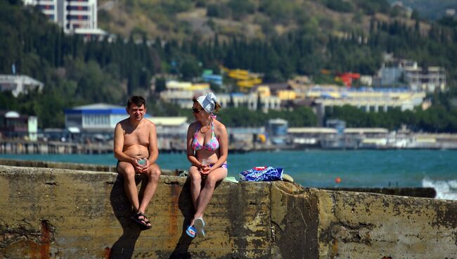 Отдыхающие загорают на волнорезе Профессорского уголка в Алуште. Архивное фото