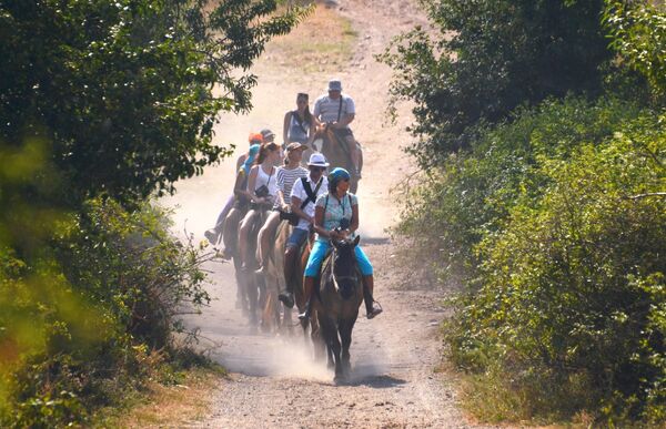 Отдыхающие катаются на лошадях в окрестностях горного массива Демерджи-яйла в Алуштинском регионе Крыма