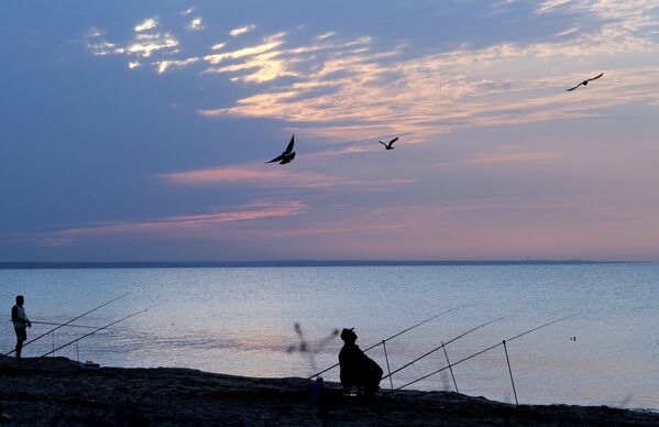 Рыбаки на закате на берегу Черного моря в районе поселка Береговое под Феодосией