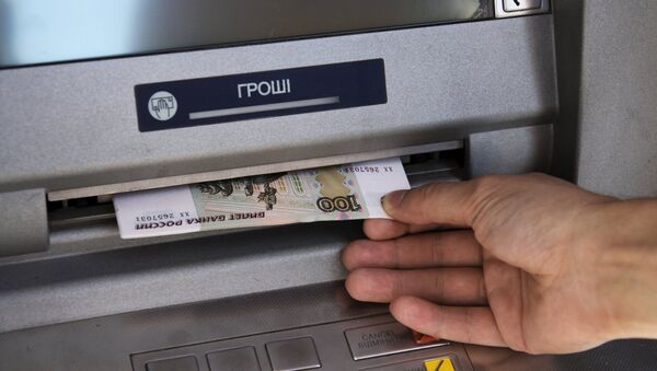Горожанин обналичивает денежные средства в банкомате. Архив