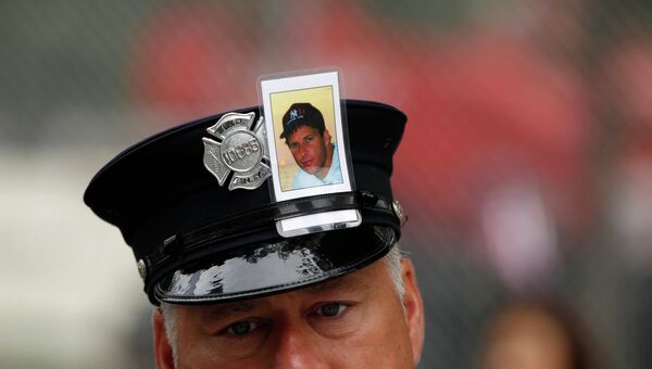 Пожарный с фотографией жертвы теракта 11 сентября 2001 года в Нью-Йорке на церемонии по случаю 10-й годовщины с момента трагедии
