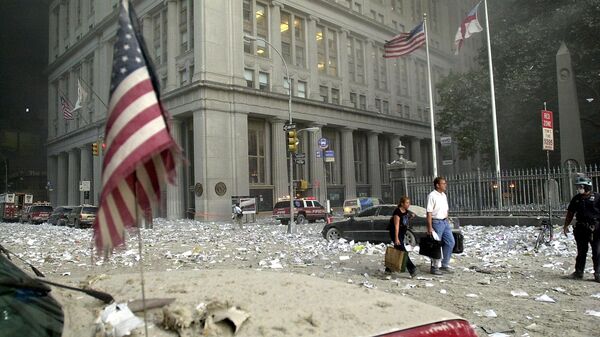 Люди идут среди обломков после разрушения башни Всемирного торгового центра 11 сентября 2001 года в Нью-Йорке