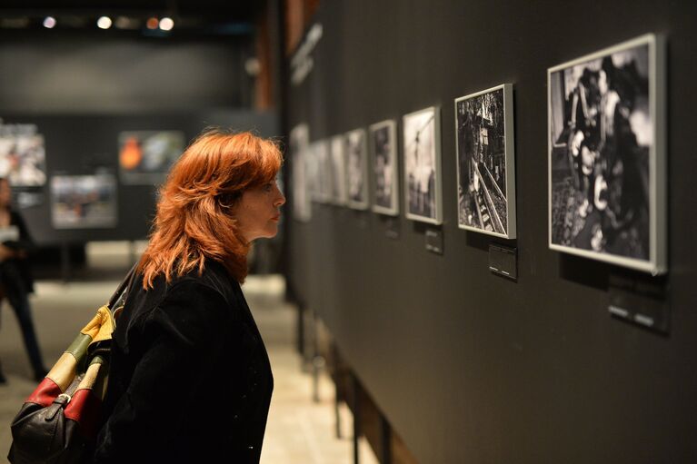 Посетительница на открытии фотовыставки победителей и призеров Международного конкурса фотожурналистики имени Андрея Стенина