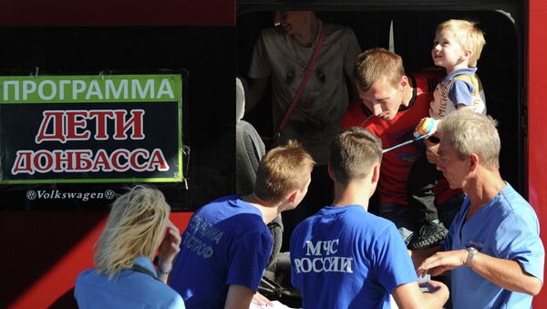 Сотрудники МЧС РФ помогают родителям с детьми из Донбасса, которые нуждаются в лечении, во время посадки на спецборт МЧС РФ в аэропорту Ростова-на-Дону перед отправкой в Москву. Архивное фото