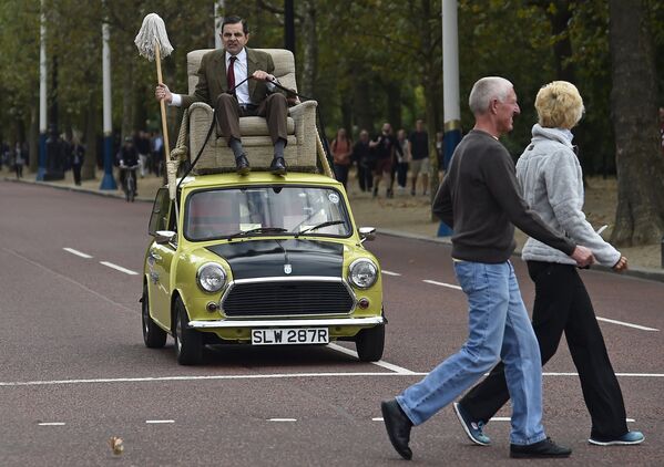 Британский комик Роуэн Аткинсон в роли мистера Бина едет на машине по центру Лондона